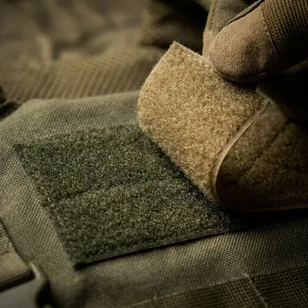 Velcro patch being removed from tactical gear showing hook and loop backing