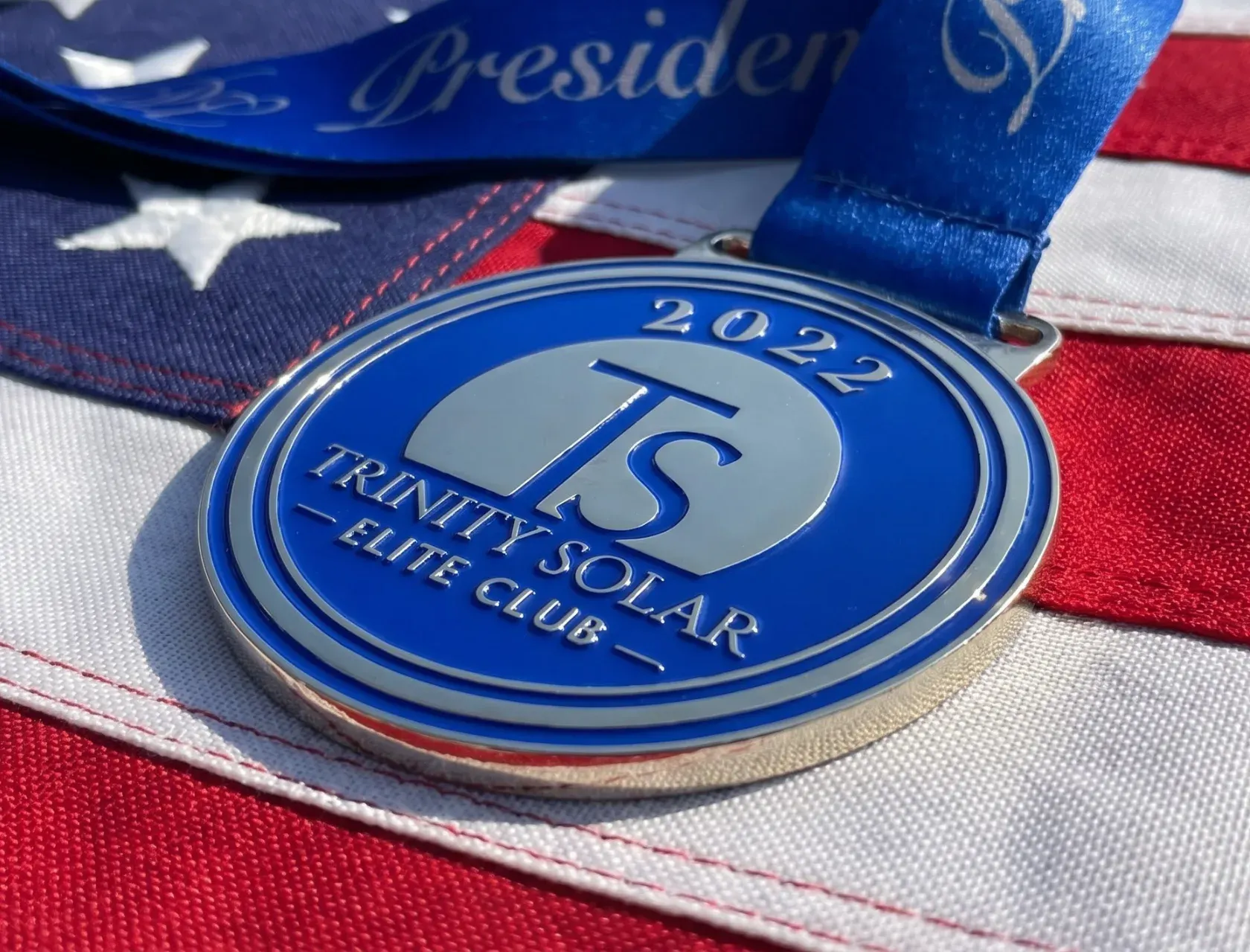 Custom award medal with ribbon showing polished metal finish, raised relief design, and personalized engraving