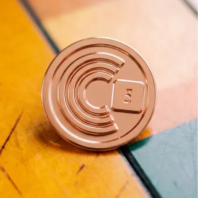 Custom service award lapel pin in rose copper with minimalist letter C design