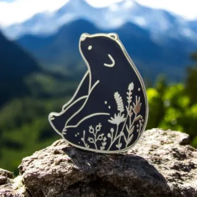 Custom die-struck lapel pin shaped like a bear silhouette on a mountain rock
