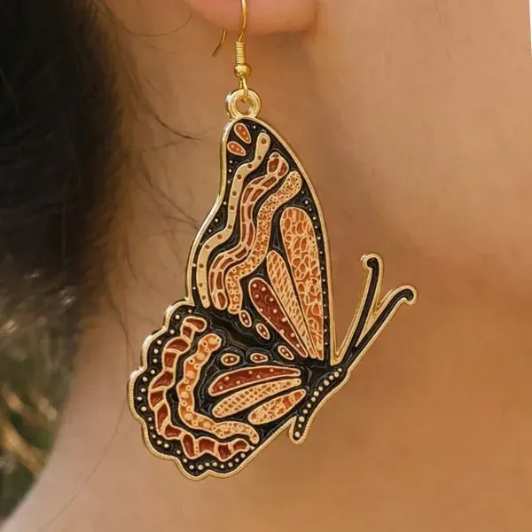 Custom orange and black butterfly dangle earring shown worn on ear