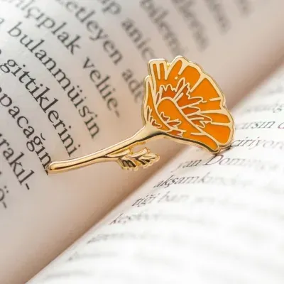 Custom soft enamel orange poppy flower lapel pin in gold finish for client branding campaigns