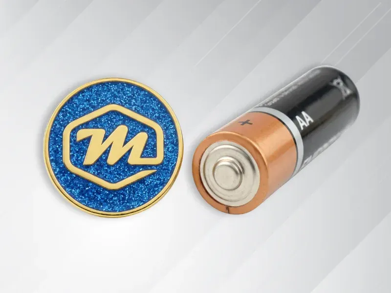 Subtle 0.5 to 0.75 inch custom lapel pin shown next to a AA battery for size reference