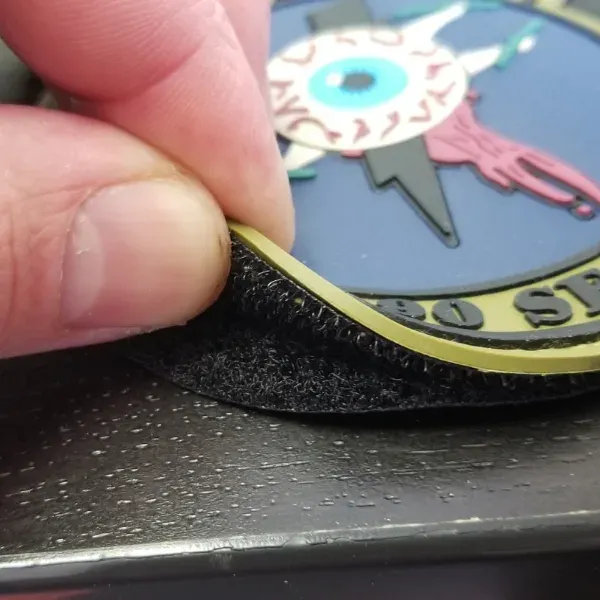 Custom hook and loop velcro patch being peeled up from backing