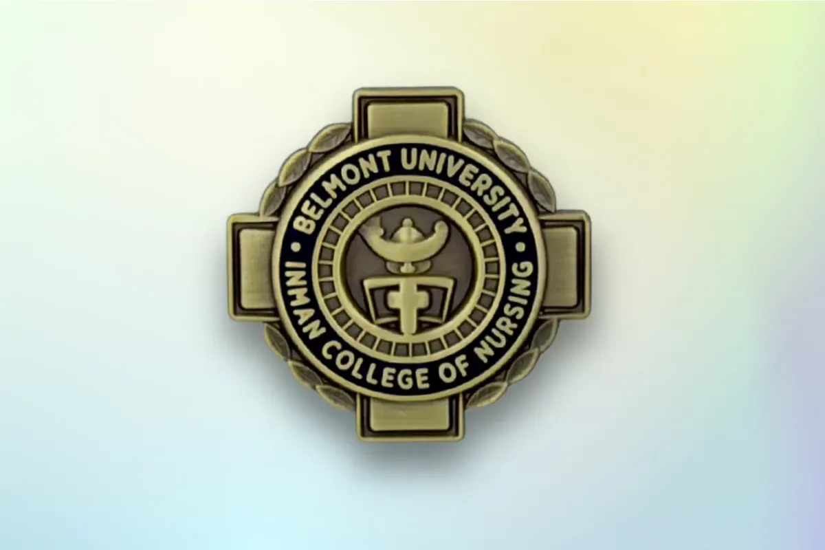 Custom die-struck nursing graduation lapel pin in antique gold with college crest and lamp emblem