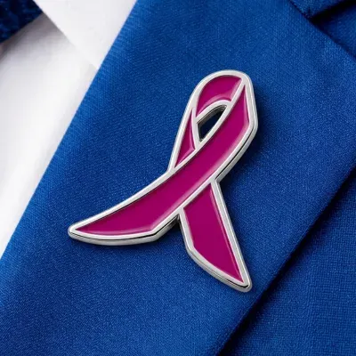 Custom soft enamel pink awareness ribbon lapel pin worn on a navy blazer