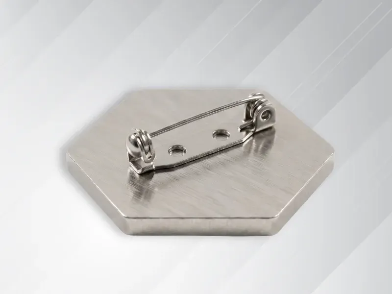 Reverse side of custom lapel pin showing horizontal safety pin attachment