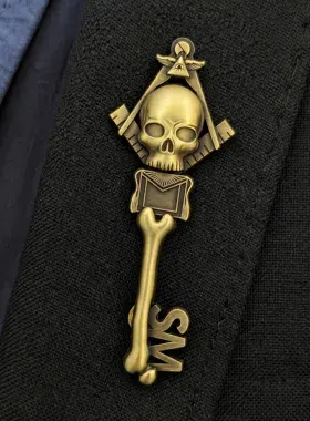 Custom die-struck motorcycle club lapel pin in antique brass with skull and key design