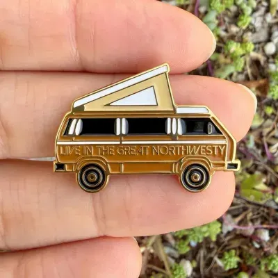 Custom 3D cast lapel pin shaped like a yellow vintage van for event branding