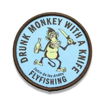 Custom woven fly fishing patch with monkey and knife design in circular border