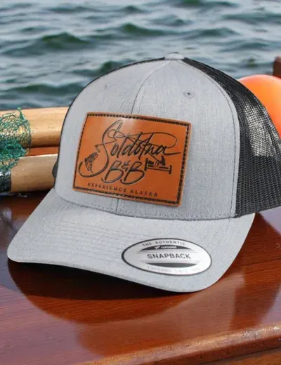 Custom leather patch on a gray and black trucker hat