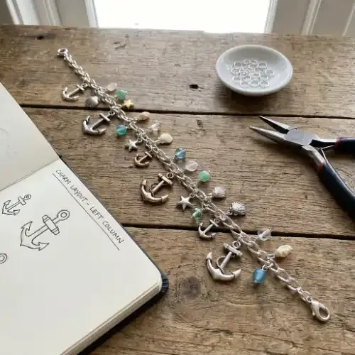 Charm bracelet in progress laid on a surface