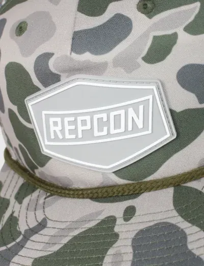 Custom white PVC Repcon patch on a camo rope hat