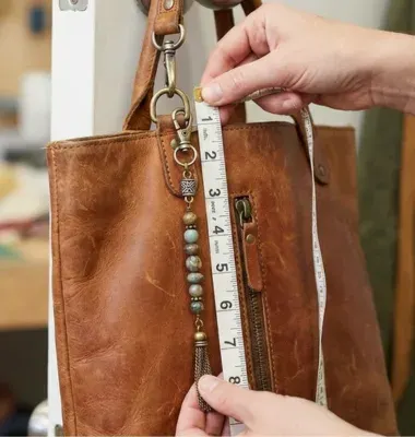 measuring a bag charm on leather purse