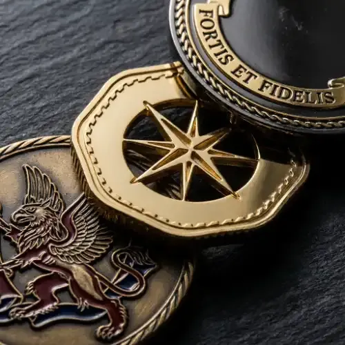 Three custom challenge coins showing detailed engraving, color fill, cutout shapes, dual-plating, and edge treatment options that separate a meaningful coin from a generic token