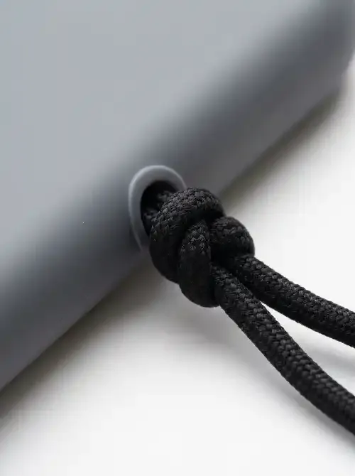 Close-up of a tight double overhand knot at a phone case lanyard hole attachment point