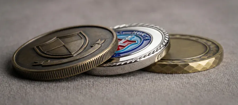 Custom challenge coins showing different finishes and edge styles including antique, polished, and enamel fill