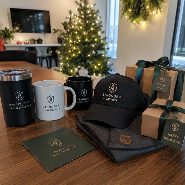 Branded coffee mug and custom cap displayed at an office holiday gathering