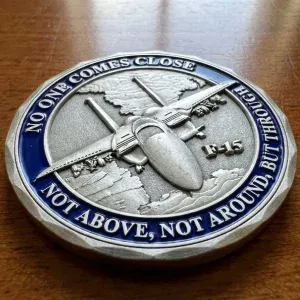 Custom challenge coin with 3D sculpted school building held in hand